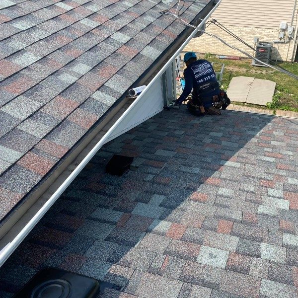 Employee workign on roof of home